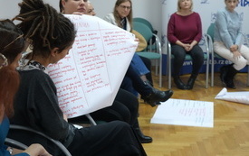 Kobieta trzyma zapisaną kartkę papieru i czyta.