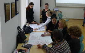 Kilkoro bibliotekarek pisze na kartce.