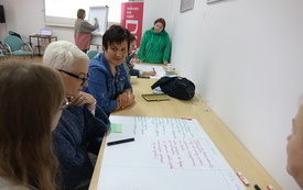 Kilkoro bibliotekarek pisze na papierowej planszy.