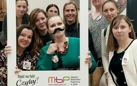 Bibliotekarki na zdjęciu grupowym z ramką i gadżetami.