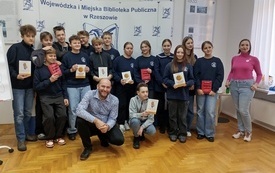 Grupa młodych ludzi pozuje do wsp&oacute;lnego zdjęcia.