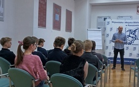 Mężczyzna przemawia do zgromadzonej publiczności.