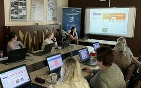Kobiety przy stole. Pracują na komputerach. 