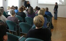 W sali zebrani goście na projekcji filmu. Na ścianie prezentacja multimedialna.