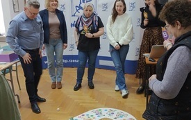 Na podłodze gra. Wokół niej osoby grające.