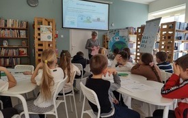 Dzieci przy stolikach podczas zajęć.