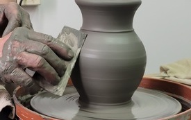 Na kole garncarskim naczynie z gliny.