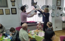 Opiekunowie tworzą girlandę z papierowych barank&oacute;w