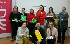 Zdjęcie grupowe 9 os&oacute;b z klockami Lego po szkoleniu. 