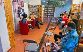 Zdjęcie wnętrza biblioteki wraz z uczestnikami spotkania.