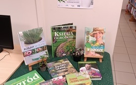 Na stoliku wyłożone książki o tematyce ogrodniczej.