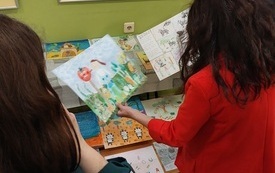 Trzy kobiety przeglądają prace konkursowe