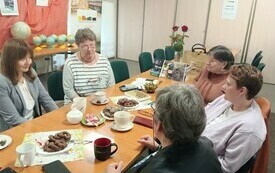 Kilka kobiet siedzi przy stole i dyskutuje.