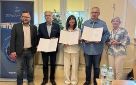 Trzech mężczyzn i dwie kobiety pozują do wspólnego zdjęcia.