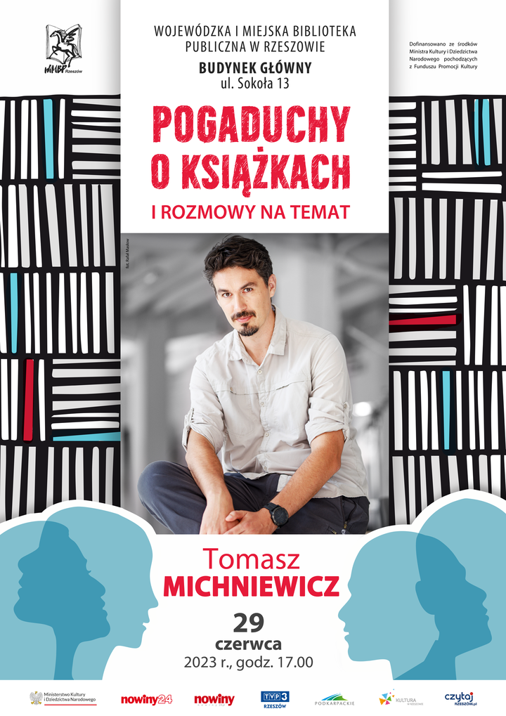 Młody mężczyzna w szarej koszuli, z brodą i wąsami siedzi z nogą założoną na nogę. Wokół grafika prezentująca książki ułożone na regałach