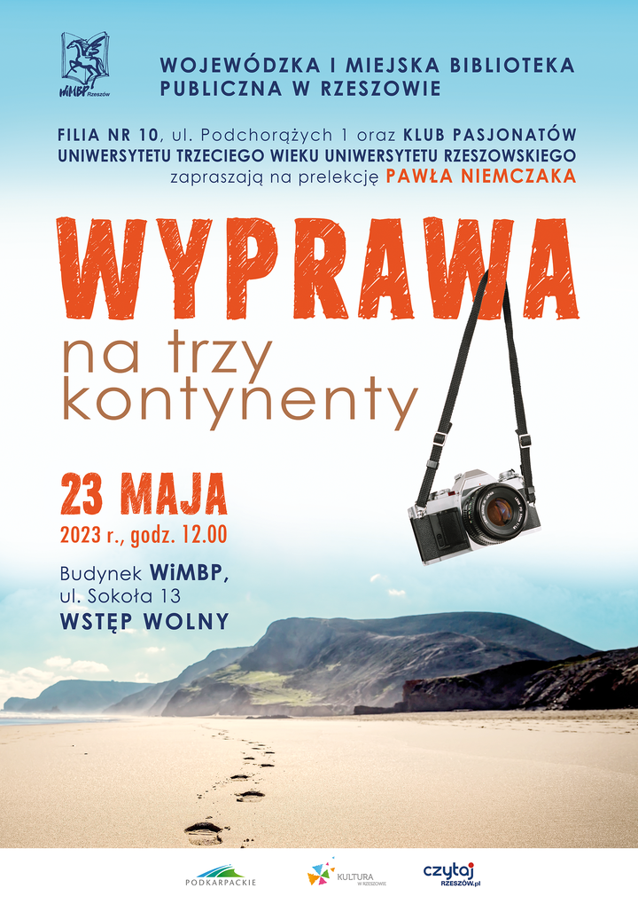 Plaża, w tle góry. Na piasku ślady stóp.