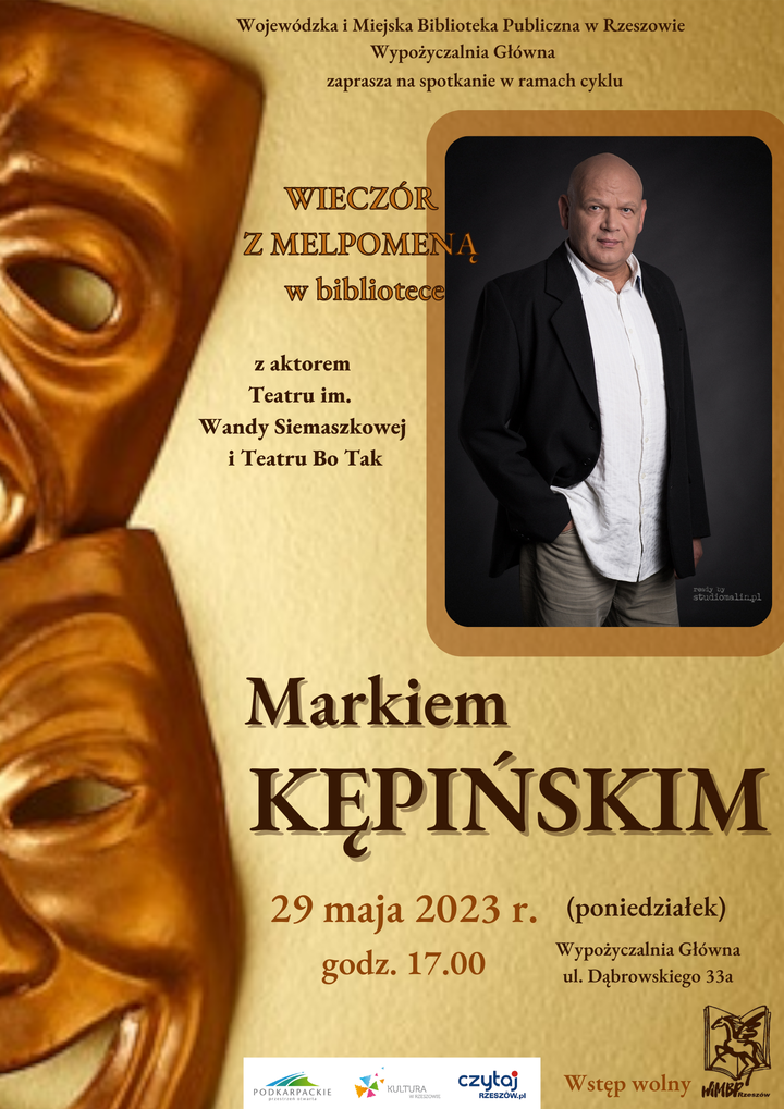Dwie maski teatralne, obok mężczyzna w białej koszuli i czarnej marynarce. 