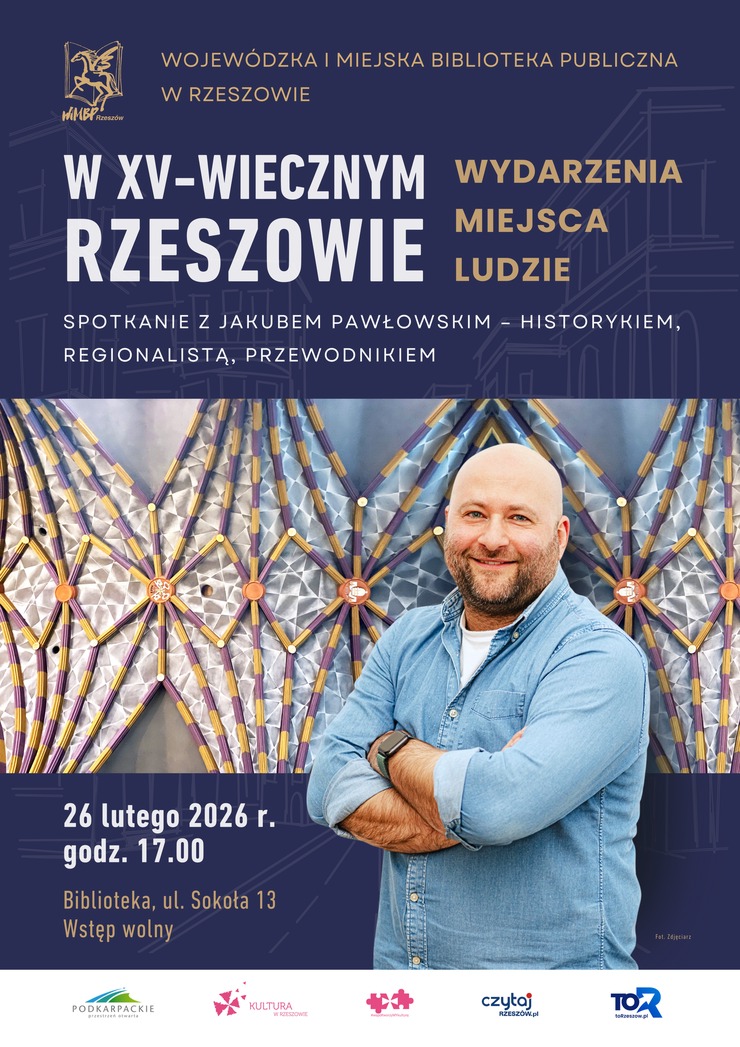 Mężczyzna z&nbsp;zarostem w&nbsp;koszuli, w&nbsp;tle sklepienie krzyżowo-żebrowe